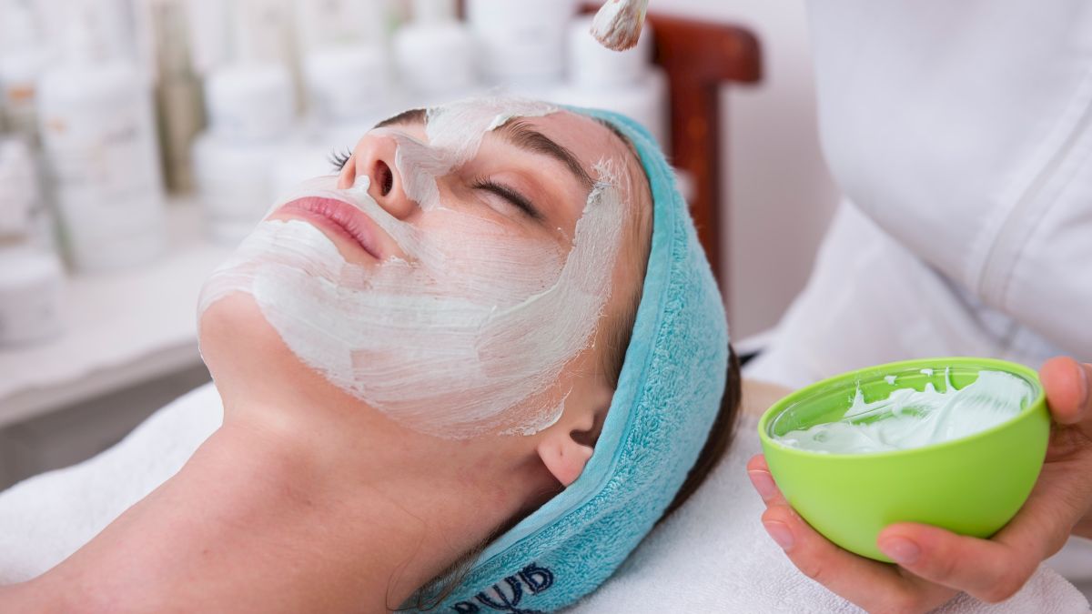 Person receiving a facial mask treatment at a spa.