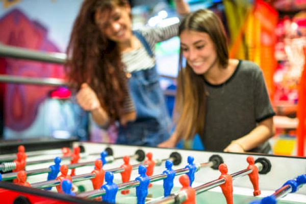 Two people are enjoying a game of foosball.