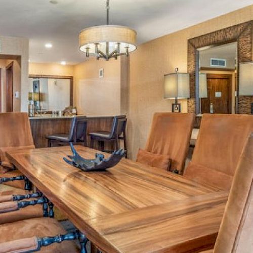 A well-appointed board room with a large wooden table and leather chairs.